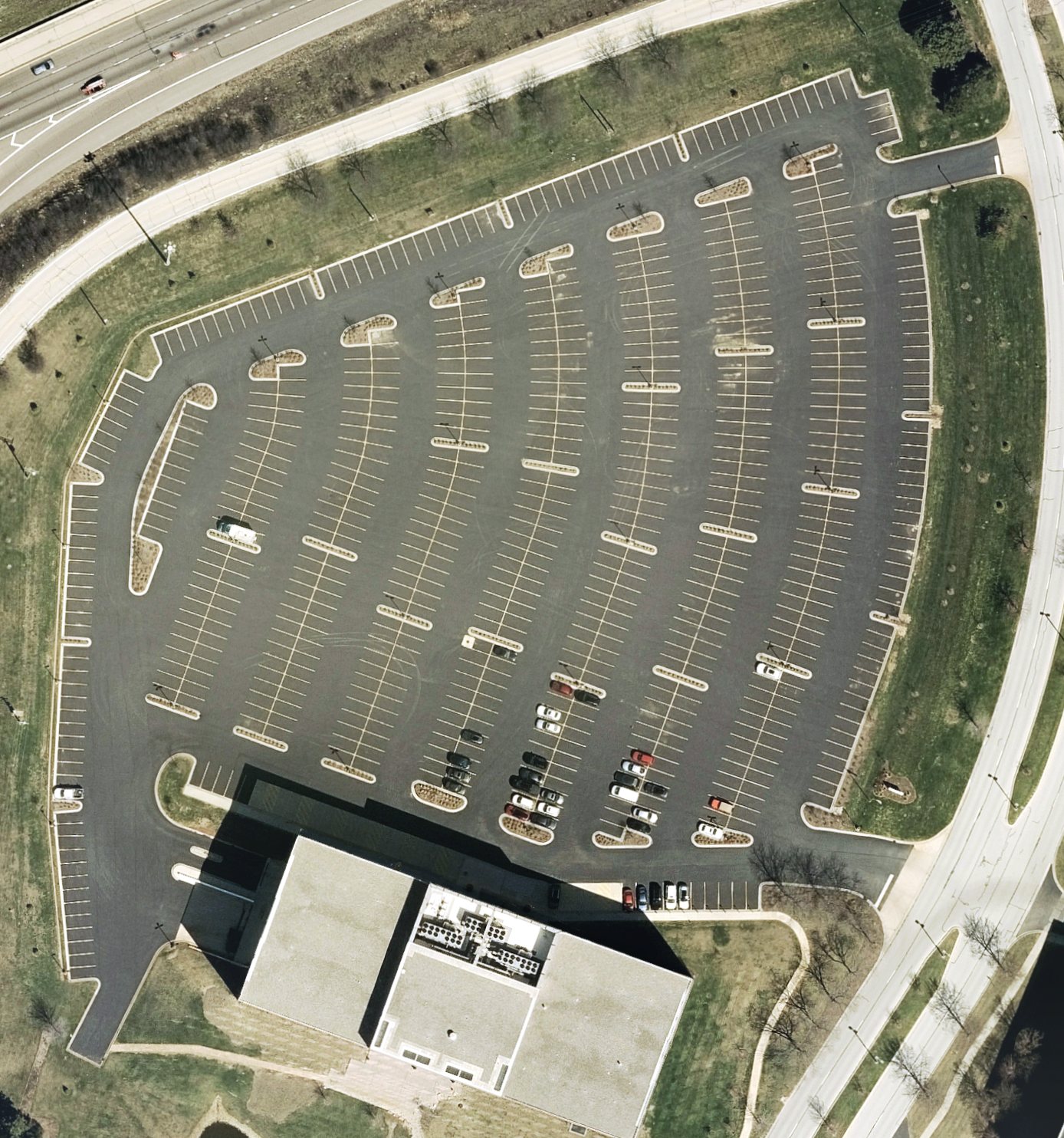 Aerial photo of an office parking lot in Justice, Illinois, with its paved area outlined in yellow and 30 landscape islands outlined in white.